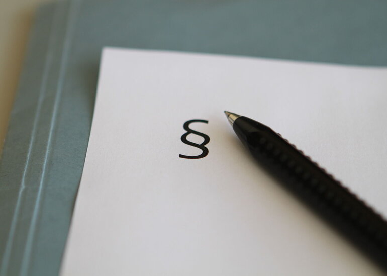 Paragraphenzeichen und Kugelschreiber