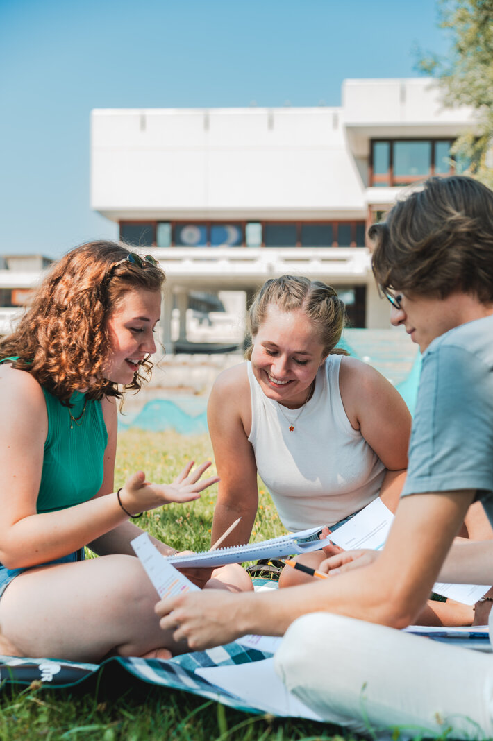 Studierende sitzen zusammen am Campus der Universität Regensburg. (öffnet Vergrößerung des Bildes)