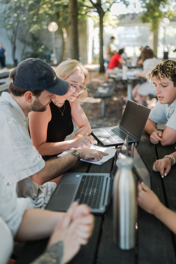 Studierende sitzen zusammen an einem Tisch im "Biergarten" in der Chemie-Cafeteria der Universität Regensburg.