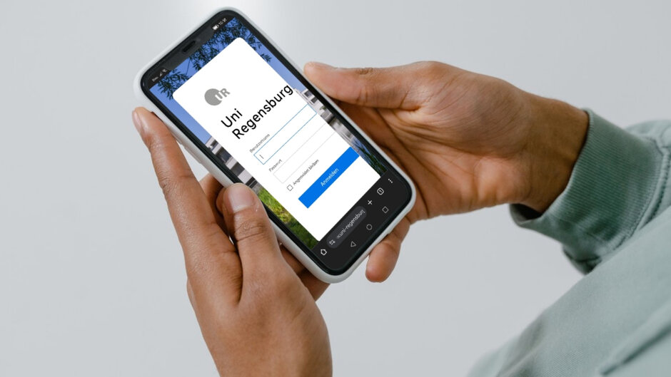 Zwei Hände halten ein Smartphone, auf dem eine Login-Seite der Uni Regensburg zu sehen ist.