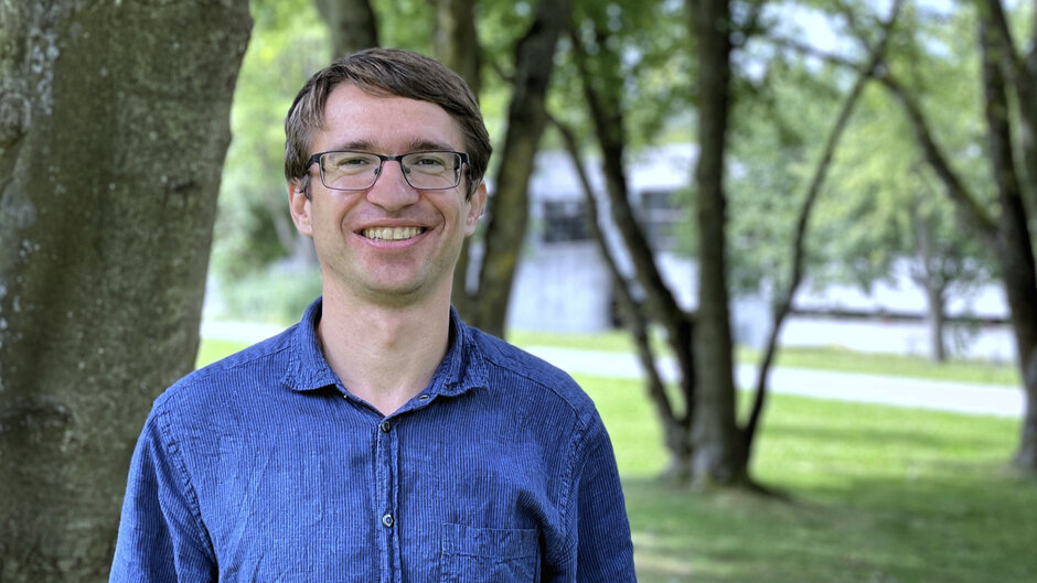 Ein Mann mit Brille und blauem Hemd blickt lächelnd in die Kamera. (opens enlarged image)