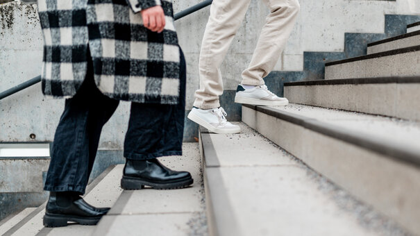 Zwei Menschen gehen eine Treppe hinauf.